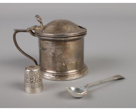 A silver mustard with spoon and blue glass interior, assayed Birmingham 1932 with a Charles Horner Dorcas thimble.47.3g