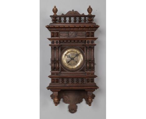 A German Kienzle wall clock, with carved detailing and bobbin gallery. The brassed dial having Arabic Numeral markers, with '