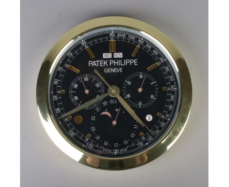A Patek Philippe watch style wall clock, featuring a gold bezel and black dial, quartz movement, diameter 40cm.  Slight warp 