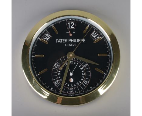 A Patek Philippe watch style wall clock, featuring a gold bezel and black dial, quartz movement, diameter 40cm.  warping to d