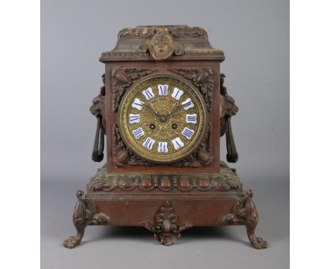 A substantial bronzed ornate mantel clock, featuring blue and white enamel Roman Numeral markers within a gilt dial and twin 