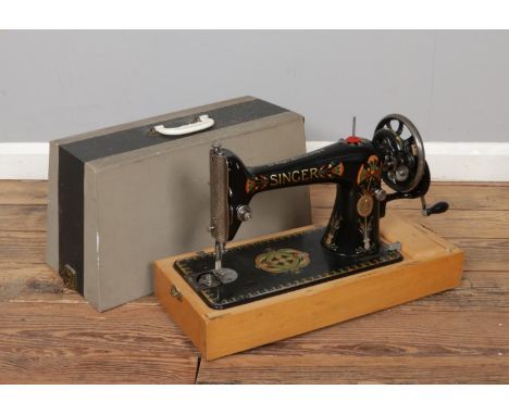 An early 20th century cased Singer hand crank sewing machine.