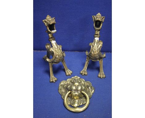 A PAIR OF BRASS FIRE DOGS TOGETHER WITH A LARGE BRASS LIONS HEAD DOOR DOOR KNOCKER