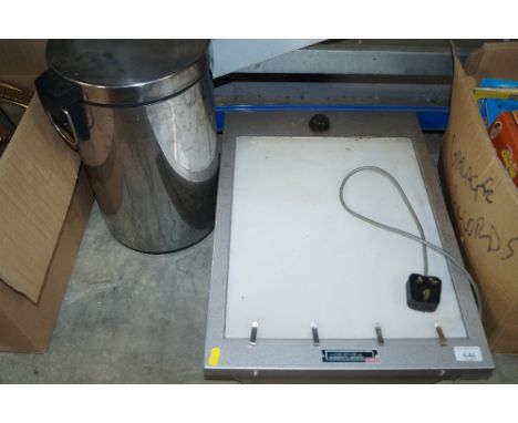 A stainless steel peddle bin and a cold light illuminator