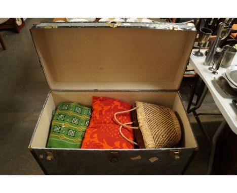 A travelling trunk and contents of various linen; a basket etc