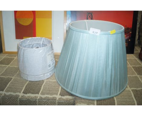 A blue lamp shade together with a pair of lamp shades