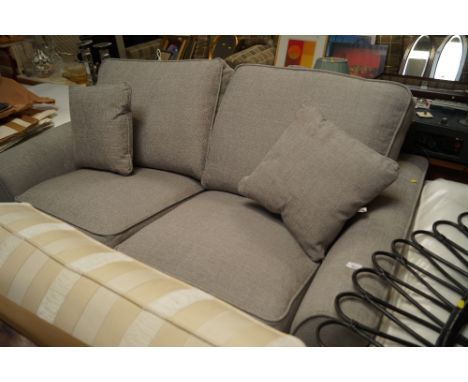 A grey upholstered two seater sofa bed