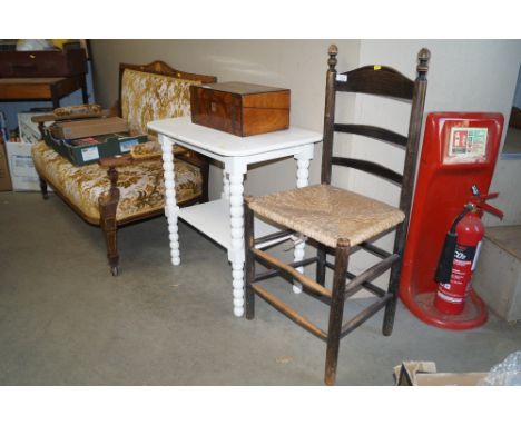 An oak ladder back rush seated chair and a white painted two tier table raised on turned supports