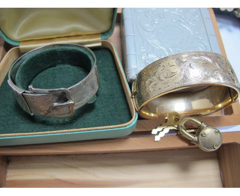 A Hallmarked Silver Vintage Style Bangle, with textured buckle detail; together with another bangle, of part foliate engravin