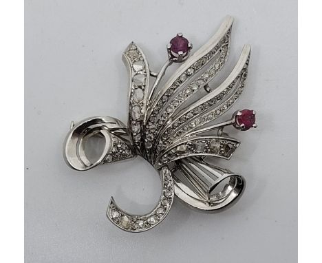 An 18ct. white gold, diamond and ruby floral spray brooch, claw set two mixed round cut rubies and pave set numerous rose-cut