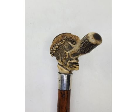 A humorous Victorian carved antler and silver mounted malacca walking stick, 1882, the handle formed from the cornet of an an