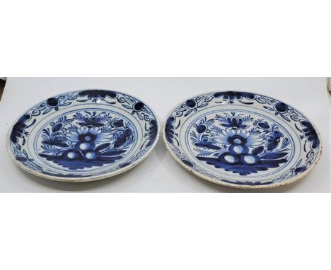 A pair of mid 18th century Dutch Delft plates, painted in blue, diameter 23.4cm. (2)  Condition note: fritting to rim on both