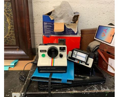 Shelf of camera equipment, polaroid, Toshiba laptop, reading devise in Waterstones case, binoculars, cat/dog carry bag etc