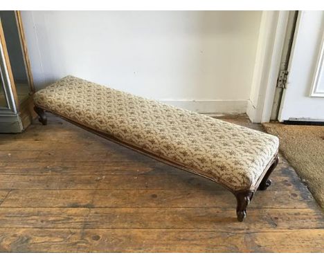 A Victorian walnut slope front fender stool, the rectangular top upholstered in floral tapestry, raised on carved cabriole su