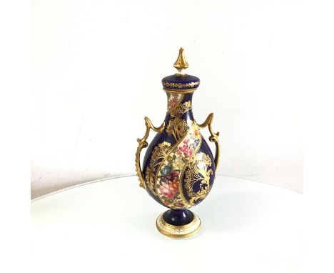 A Royal Crown Derby urn shaped two handled vase complete with cover, decorated with scrolling floral panel with beaded gilded