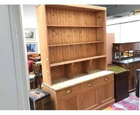 A 19thc stripped pine two part dresser, the moulded top above four open shelves, three frieze drawers and three inset panel d