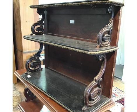 A 19thc rosewood and ebony brass mounted three tier wall shelf, with brass mounted top and S scroll twin end supports (68cm x