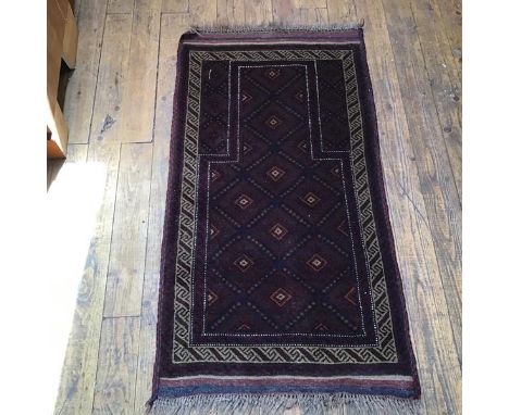 A Persian prayer rug, the shaped centre panel with diamond and flowerhead interior, enclosed within running dog and geometric