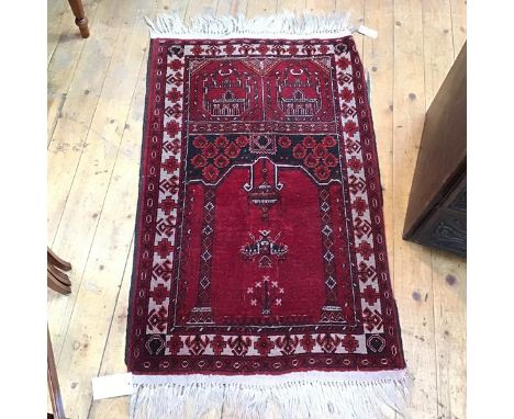 A Persian prayer rug, the centre panel with hanging lantern and figures, red field (118cm x 76cm)