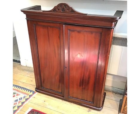 A mahogany Victorian hanging cabinet, with panelled doors and shelved interior with one glass shelf (29cm x 77cm x 26cm)