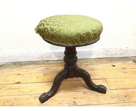 An early 20thc circular stool, the upholstered seat with fleur de lys decoration, on a turned support and carved tripod base 