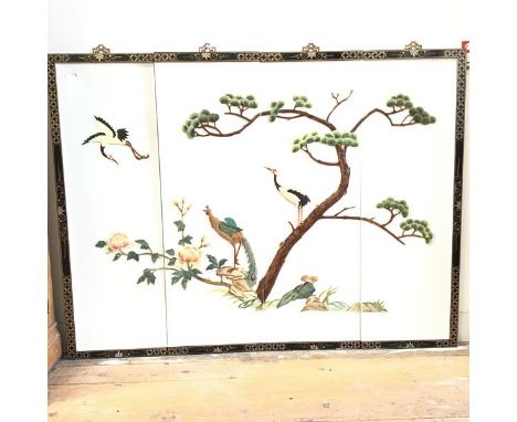 A Chinese four panel wall screen applied in coloured soapstone with birds and pine tree, in ebonised and gilded mother of pea