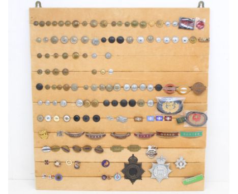 Railwayana: A board of assorted railwayana badges and buttons to include: GWR, LMS, LNER, BR, National Rail, totem badges (Br