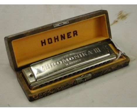 A Hohner chromonika III harmonica, cased.