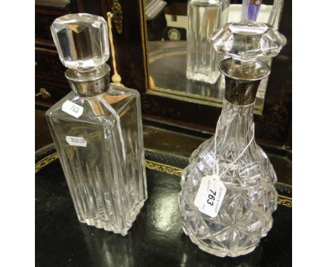 A cut-glass decanter with silver collar by Mappin & Webb Ltd., and another with silver collar, (2).