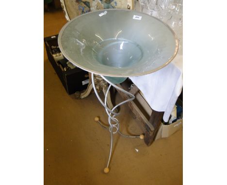 A large blue glass bowl on fitted metal tripod stand.