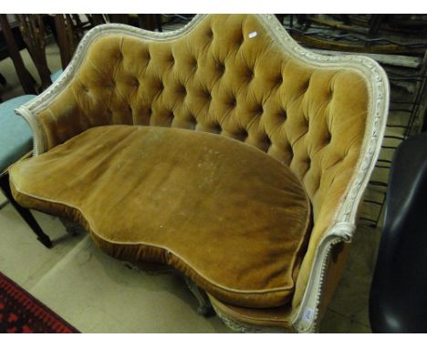 A carved and painted framed salon sofa with button back upholstery, serpentine front and cabriole legs.