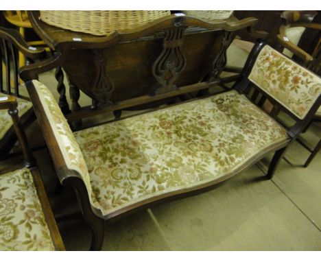 An Edwardian mahogany salon sofa with carved pierced back.