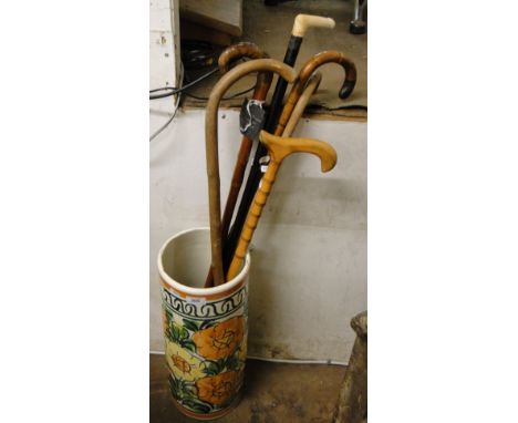 A pottery stick stand containing 6 walking sticks.