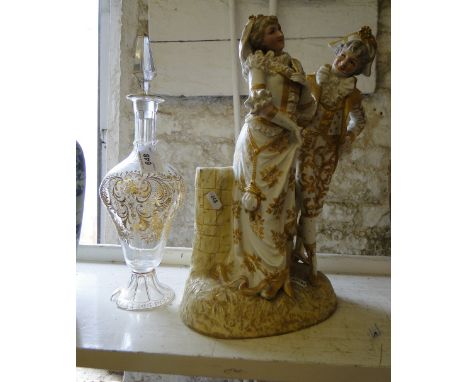 A pair of continental figures and a decanter with gilded decoration.