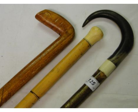 A Malacca walking cane, a horn handled walking stick and another, (3).