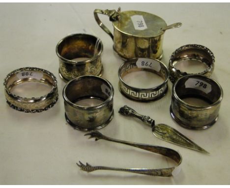 A silver mustard pot with blue glass liner and spoon, silver sugar nips, a silver trowel design bookmark and 6 various silver