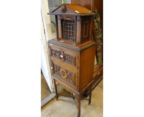 An unusual valve radio in the form of a side cabinet, the arched top forming the speaker with 2 panelled doors under revealin