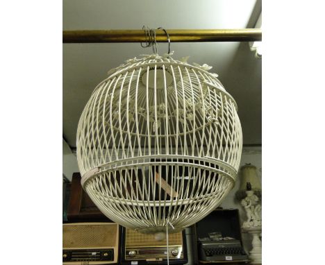 Ornamental wirework bird cage and a pink glass shaded table lamp.