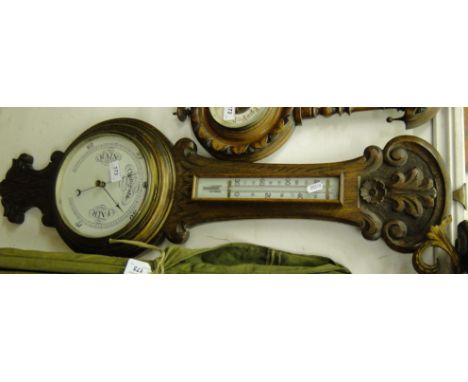 A carved oak cased aneroid barometer