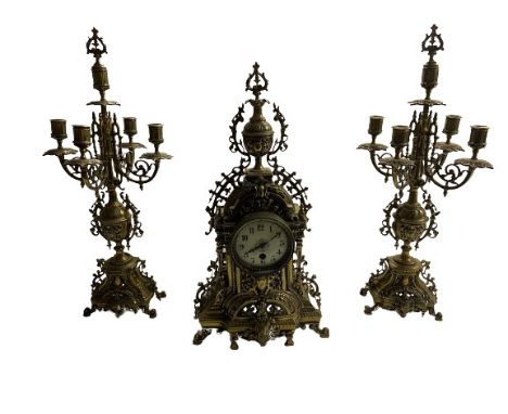 A Baroque style heavy brass pierced decorated Clock Garniture, the clock with urn finial over circular enamel dial; together 