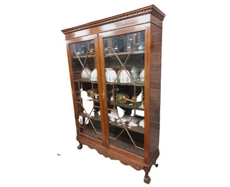 A Chippendale style mahogany Display Cabinet, with dentil moulded cornice above two astragal glazed doors on a shell carved a