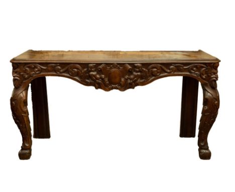 A 19th Century Provincial carved pine Side or Console Table, the rectangular moulded top above an ornate carved frieze with c