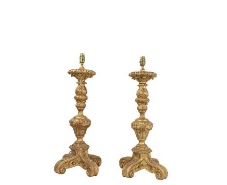 A pair of composition gilt tripod Table Lamps, each moulded with leaves and grotesque masks, 25'' (64cms). (2) 