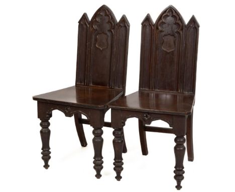 A quality pair of mahogany Gothic Revival Hall Chairs, in the manner of Pugin, the shaped backs with central arch, flanked by