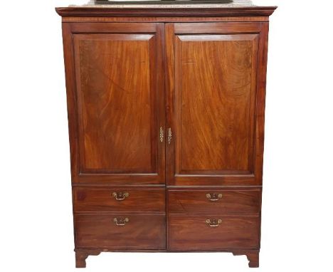 A Georgian mahogany Wardrobe, with moulded cornice above two fielded panel doors incorporating four mock drawers below on bra