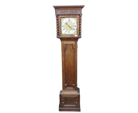 An oak Longcase Clock, in the 19th Century style, with moulded cornice above a carved frieze and a brass dial, the silverised