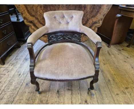 Edwardian mahogany club chair with button upholstered back rail upon short cabriole legs.