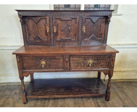 Early 20th century oak Jacobean style buffet sideboard decorated with arcaded top rail, carved floral lozenges, applied fleur