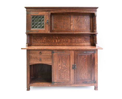 An Arts & Crafts Oak Lochleven Sideboard, retailed by Liberty & Co, the shelf back with a green bulls eye glazed cabinet with