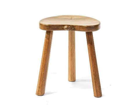 Workshop of Robert Mouseman Thompson (Kilburn): An English Oak Kidney Shaped Calf Stool, on three octagonal legs, with carved